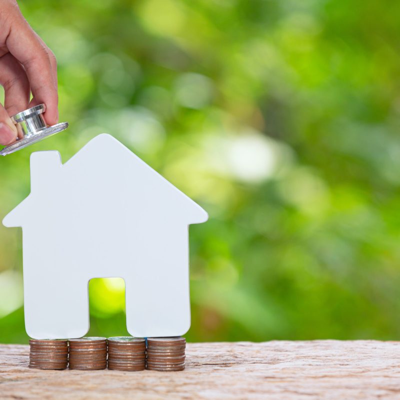 World Habitat Day,close up picture of a pile of coins and a model house